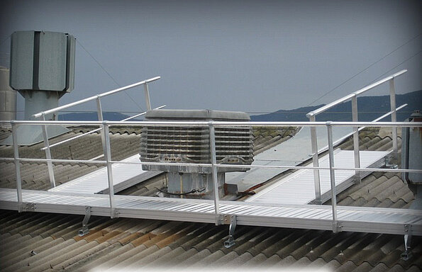 Tourelles d'extraction situées sur toiture pente traditionnelle, avec passerelle d’accès et latérales, équipées de garde-corps.