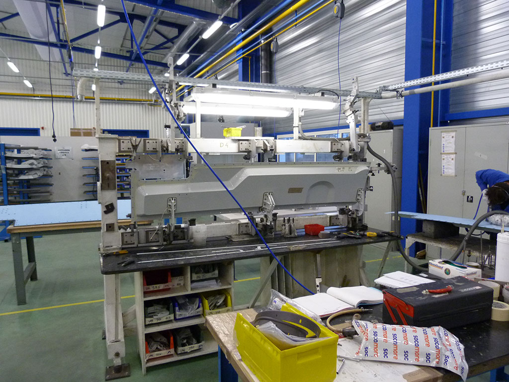 Vue de l'éclairage artificiel installé au poste d'assemblage trappe chez STELIA pour la fabrication de pièces composites aéronautiques. - Atelier de fabrication de pièces en matière composite pour l'industrie aéronautique -Éclairage artificiel -Poste d'assemblage "trappe"