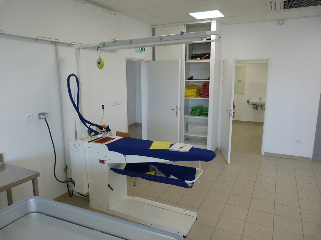 Activité blanchisserie dans un ESAT -Charge physique de travail (manutention manuelle et levage) - Poste de repassage - Table de repassage - entreprise CAMINANTE manutention