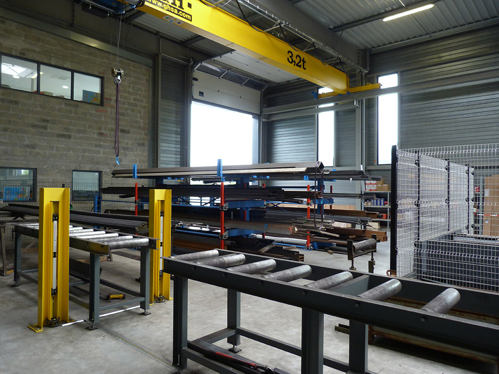 entreprise SOBLACO - Construction d’un atelier de menuiserie métallique – Circulation intérieure -Actions mises en oeuvre pour limiter le risque - Organisation générale - Passage à travers le convoyeur d'alimentation de la scie à débit.